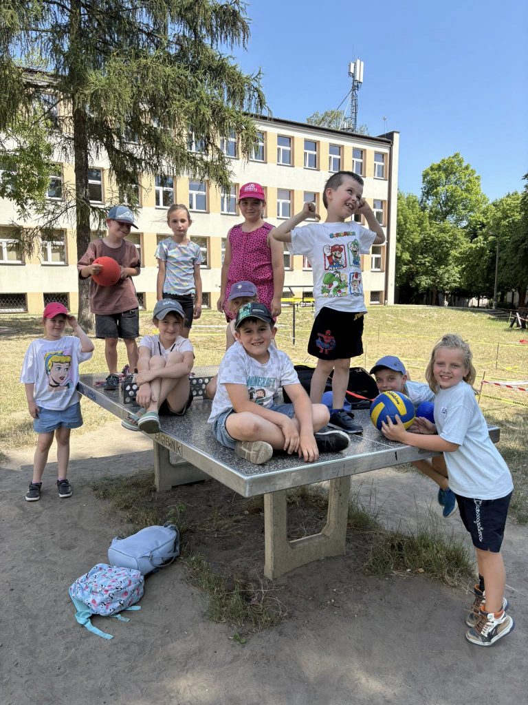 Dzieci bawiące się na zewnątrz przy stole od ping pongs