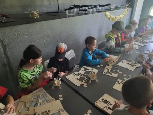 dzieci skłądają modele samolotóœ